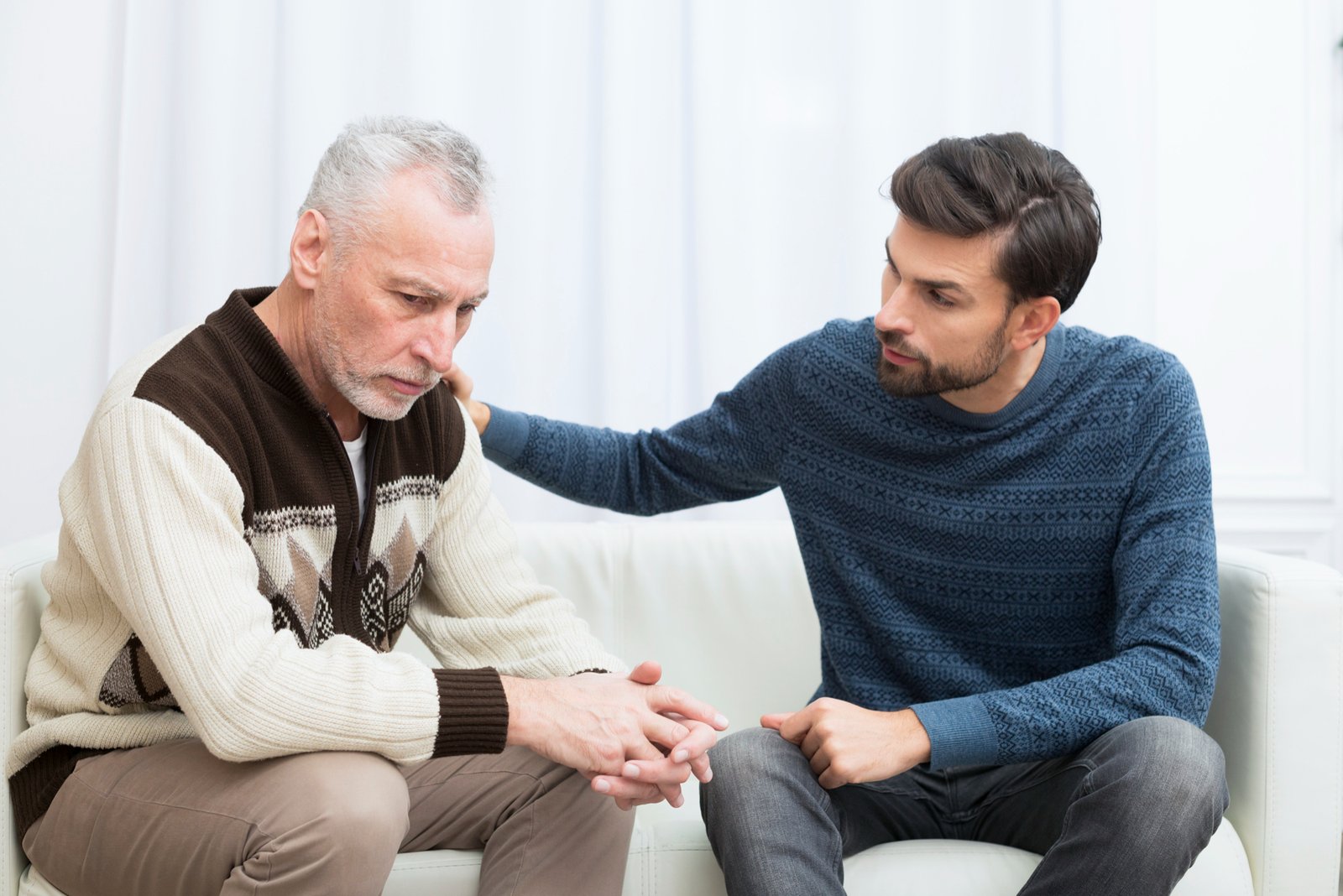 Man comforting sad older man on couch to Vulnerable Adult Assessments - Insight Psychiatry Reports ( Immigration Psychiatric Report )