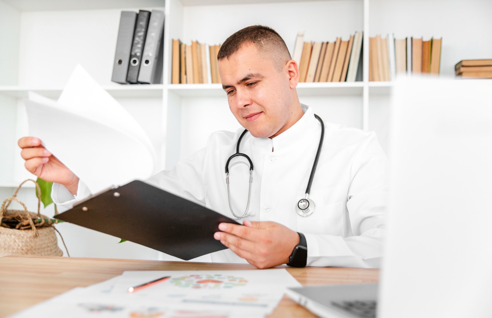 Male doctor looking at a report at a desk - Insight Psychiatry Reports
